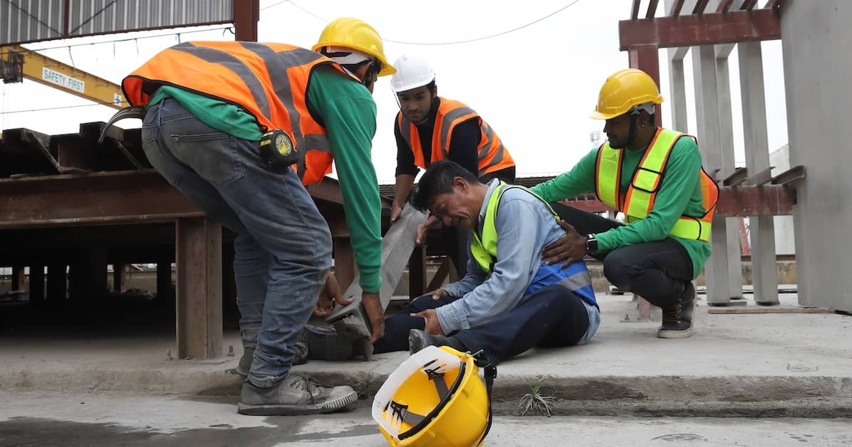 an injured construction worker surrounded by coworkers | Oliver Law Firm